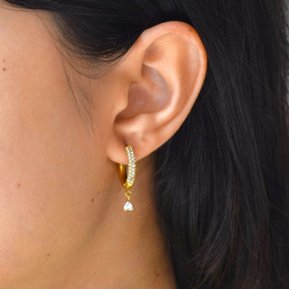 Gold Amore Drop Hoops worn on model with dangling heart charm