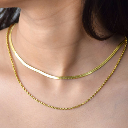 Gold layered herringbone necklace worn on model