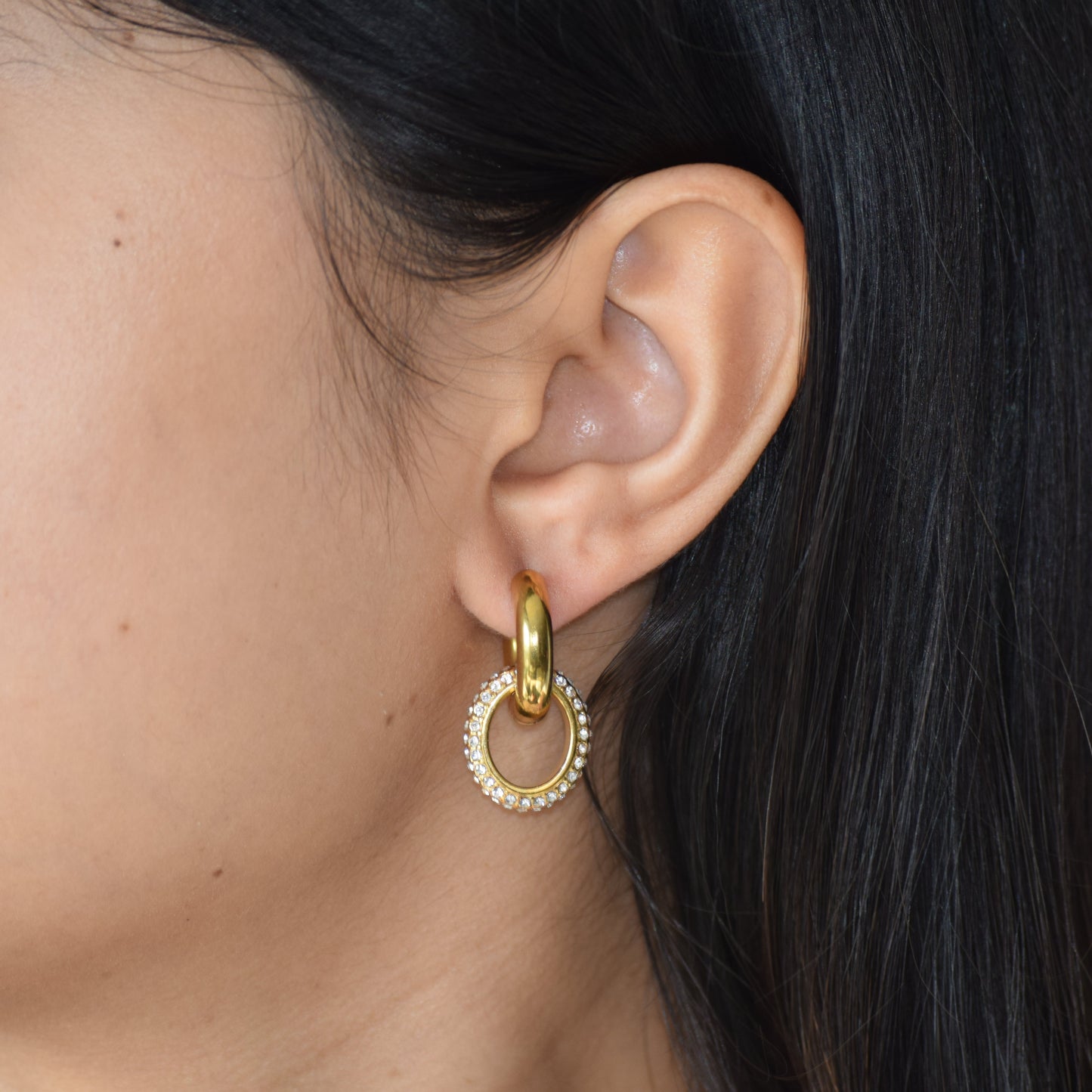 Gold Glimmer Huggie earring worn on ear
