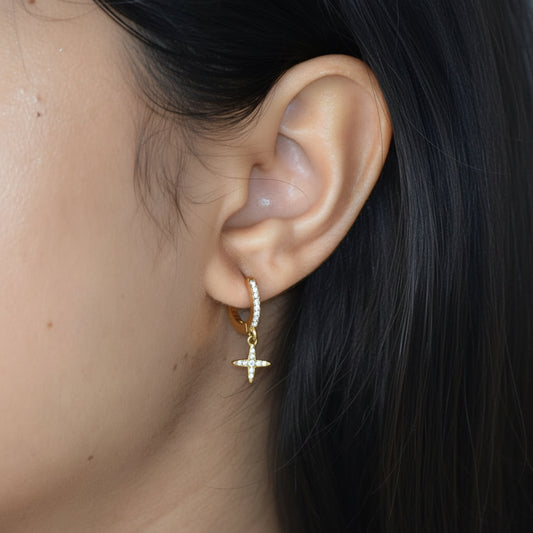 Gold Star Huggie earring worn on ear