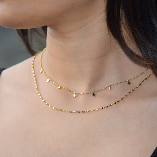Gold Charm Layered Necklace worn with delicate layered chains