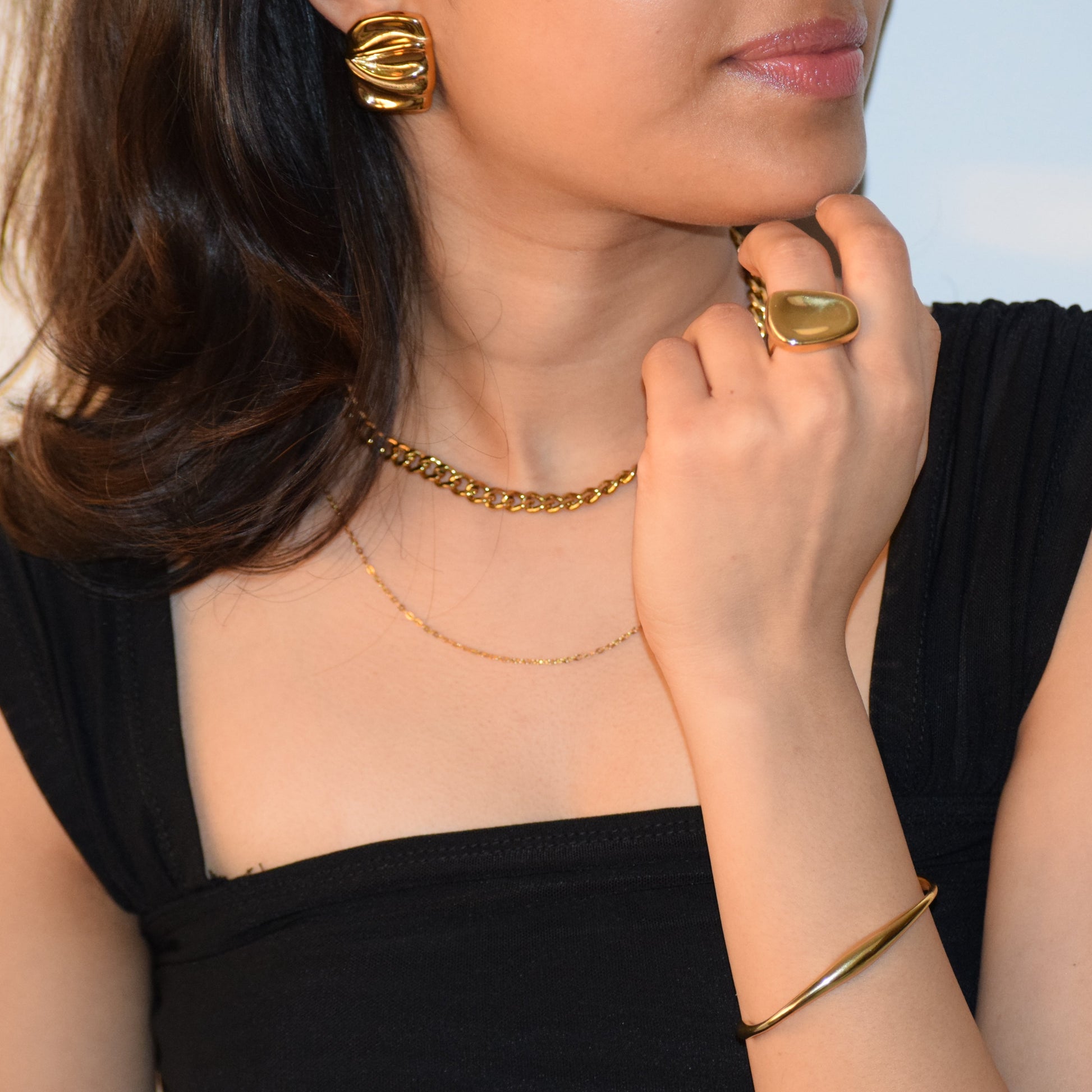 The It-Girl Necklace styled with gold rings and cuff